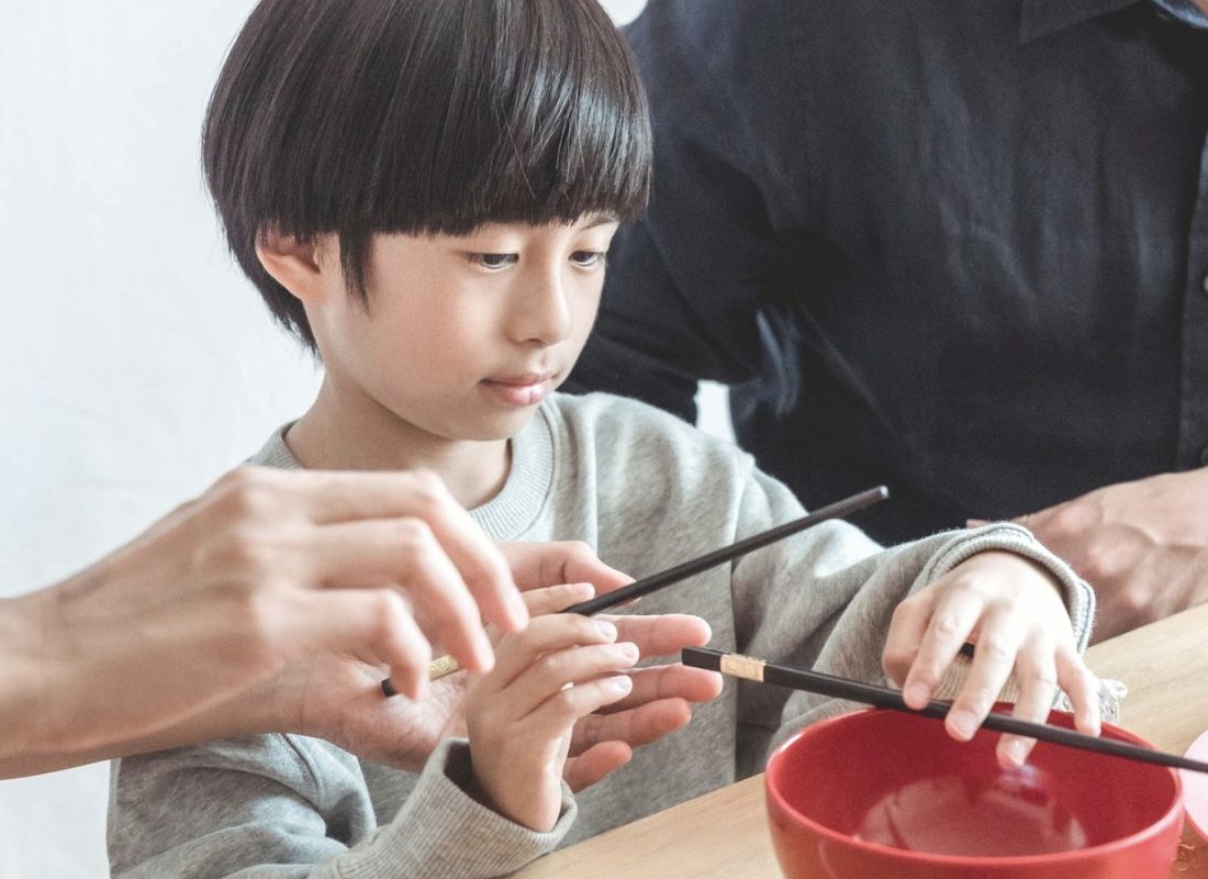 Family sharing a home-cooked meal with chopsticks